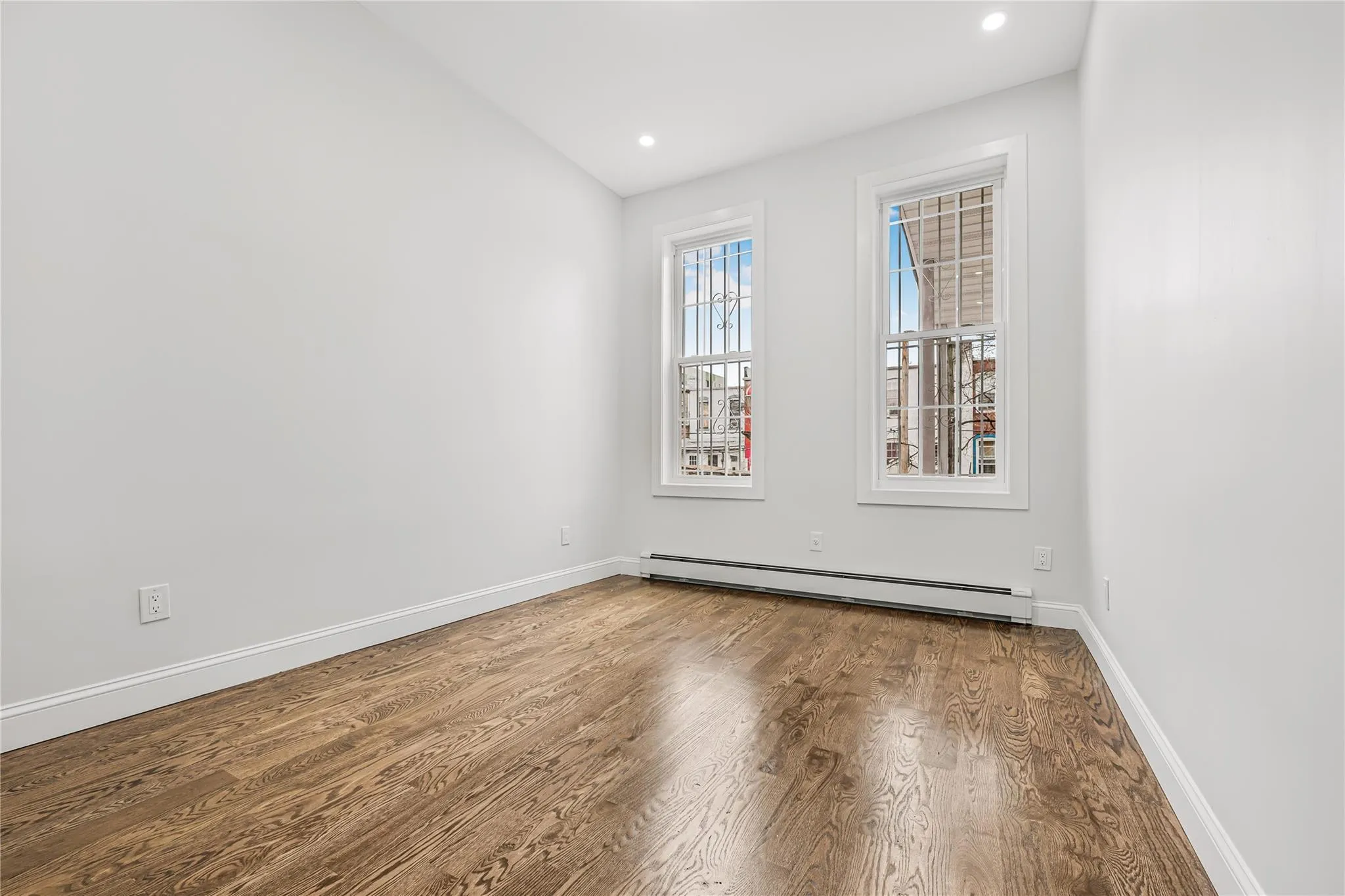 Spare room featuring wood finished floors, baseboard heating, and recessed lighting Spare room featuring wood finished floors, baseboard heating, and recessed lighting
