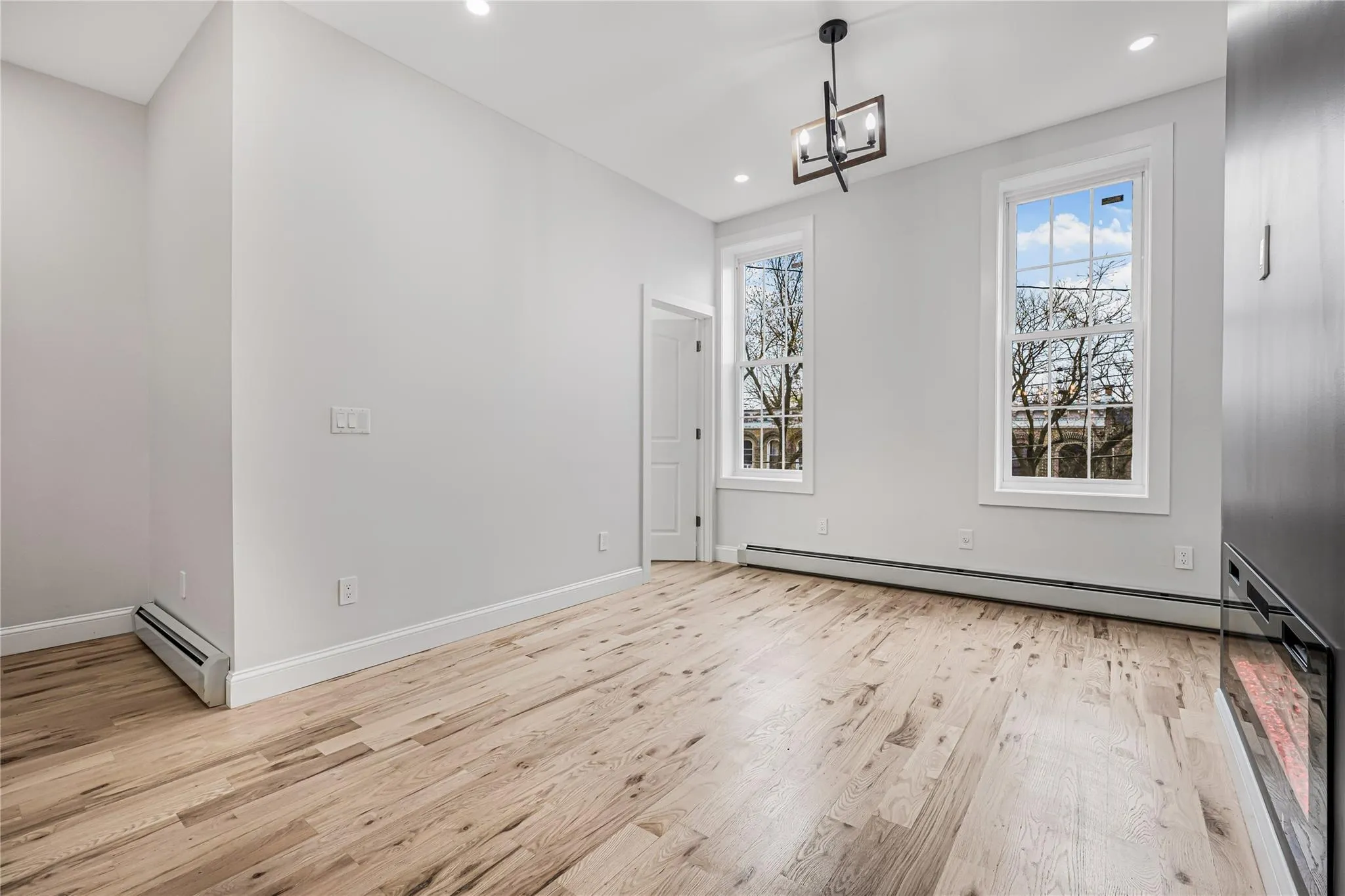 Unfurnished dining area featuring light wood-style flooring, baseboard heating, recessed lighting, and a chandelier Unfurnished dining area featuring light wood-style flooring, baseboard heating, recessed lighting, and a chandelier