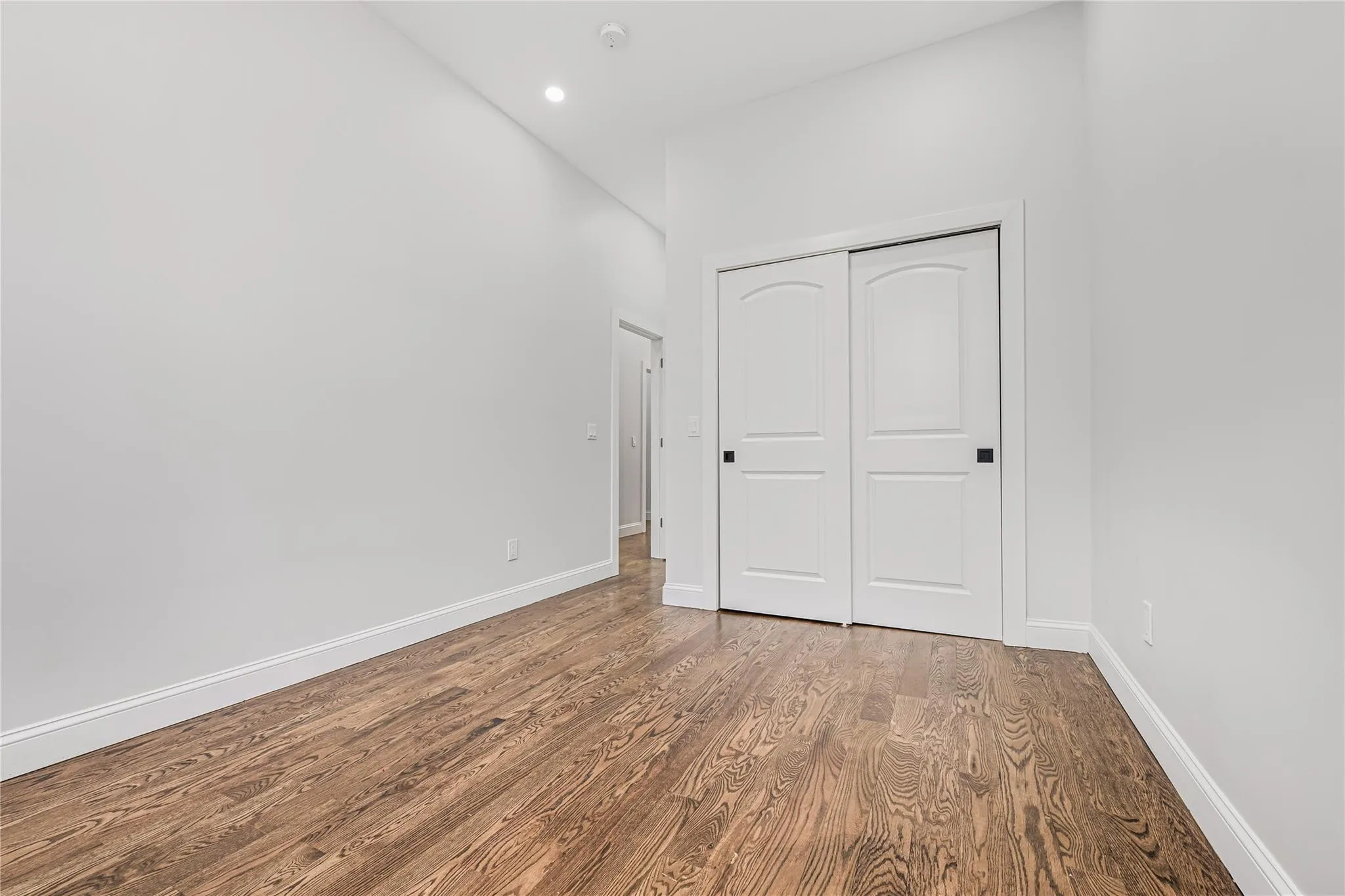 Unfurnished bedroom featuring wood finished floors, a closet, and recessed lighting Unfurnished bedroom featuring wood finished floors, a closet, and recessed lighting