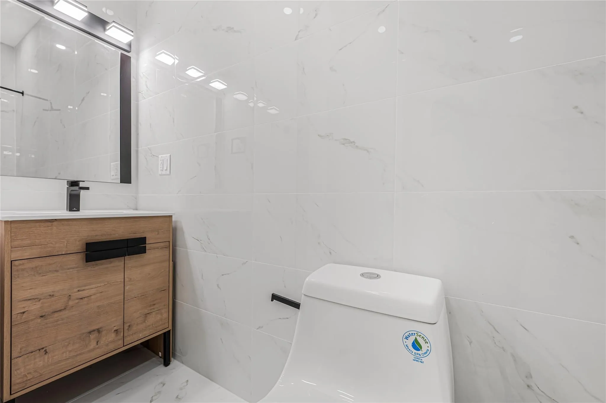 Bathroom featuring vanity, tile walls, and marble finish floors Bathroom featuring vanity, tile walls, and marble finish floors