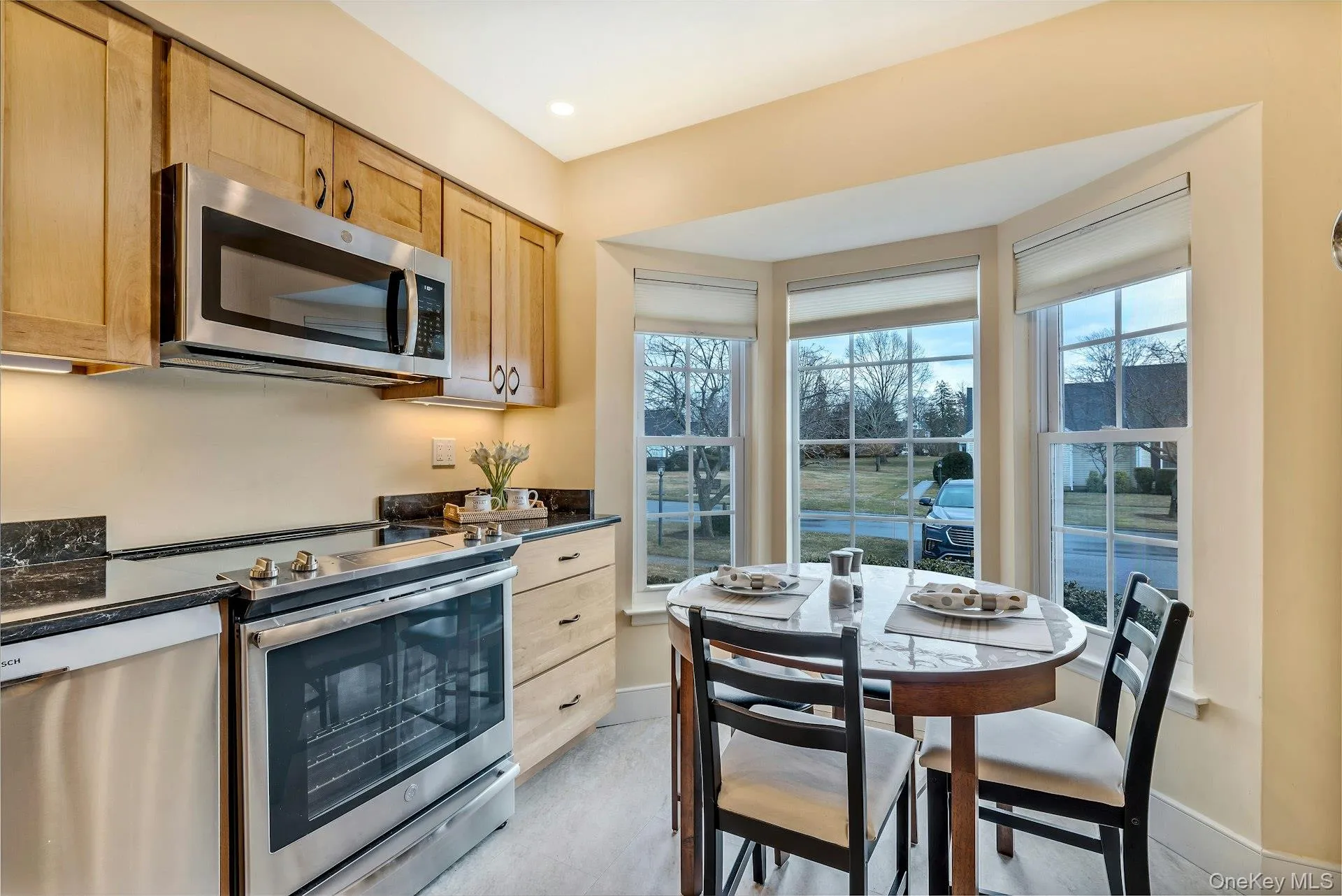 Kitchen with stainless steel appliances, healthy amount of natural light, light brown cabinets, recessed lighting, and dark stone countertops Kitchen with stainless steel appliances, healthy amount of natural light, light brown cabinets, recessed lighting, and dark stone countertops