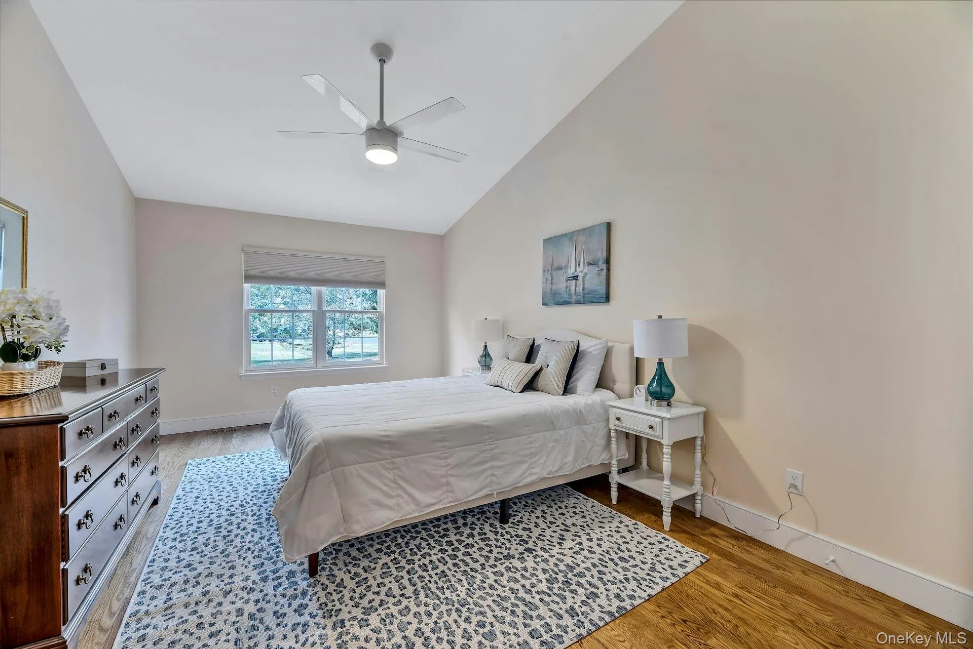 Bedroom with light wood-type flooring, high vaulted ceiling, and a ceiling fan Bedroom with light wood-type flooring, high vaulted ceiling, and a ceiling fan