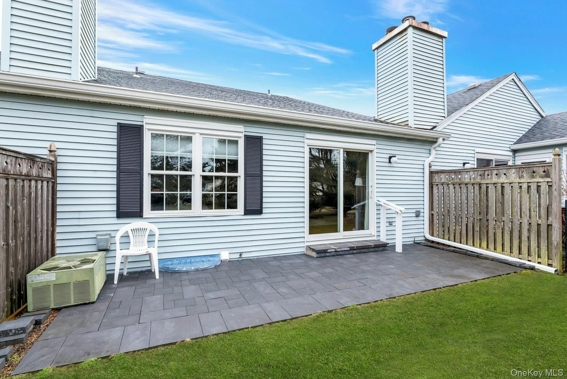 Back of property featuring a fenced backyard, a patio, a shingled roof, and a chimney Back of property featuring a fenced backyard, a patio, a shingled roof, and a chimney