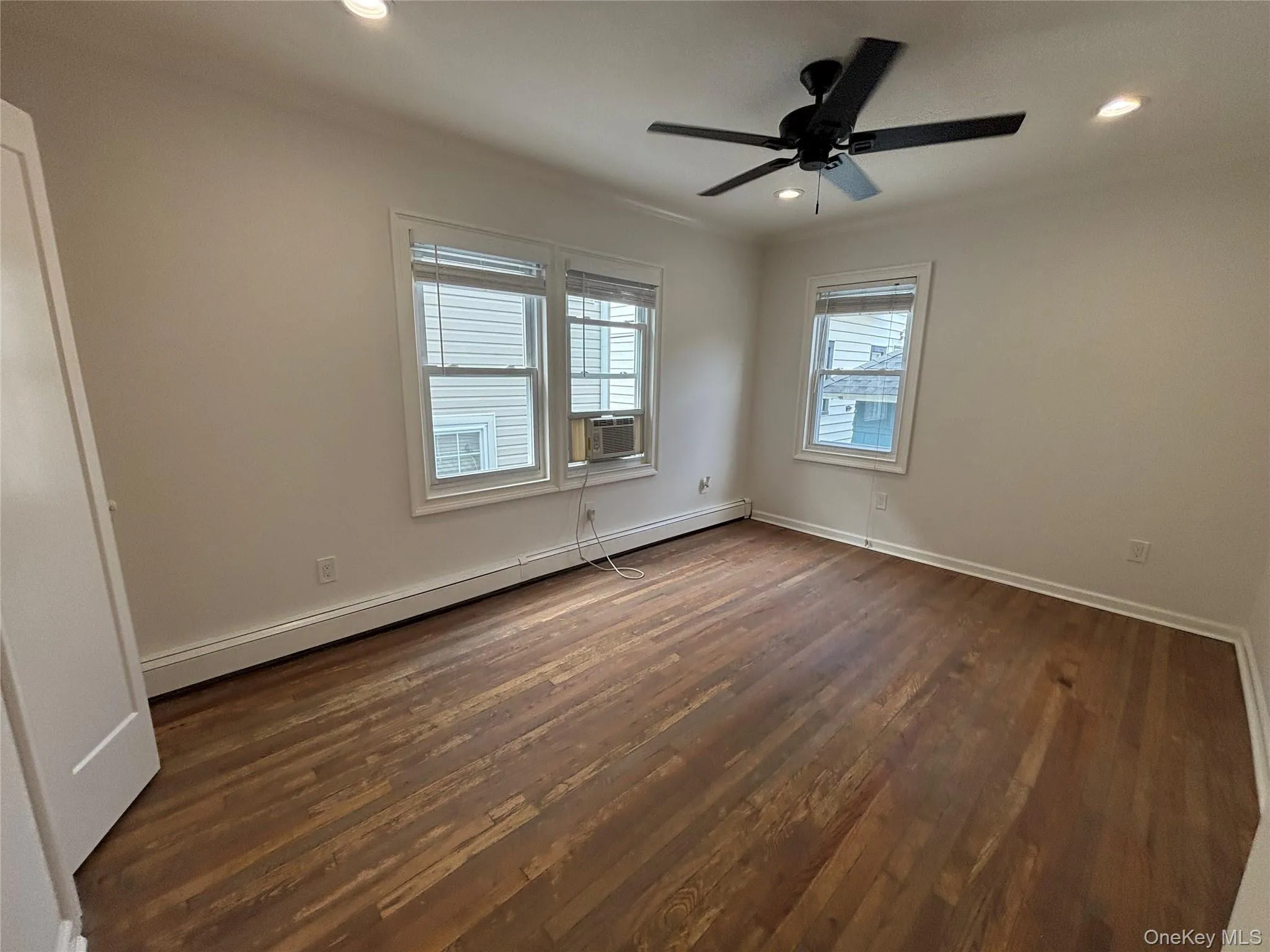 Empty room with dark wood-type flooring, a baseboard heating unit, recessed lighting, crown molding, and a ceiling fan Empty room with dark wood-type flooring, a baseboard heating unit, recessed lighting, crown molding, and a ceiling fan