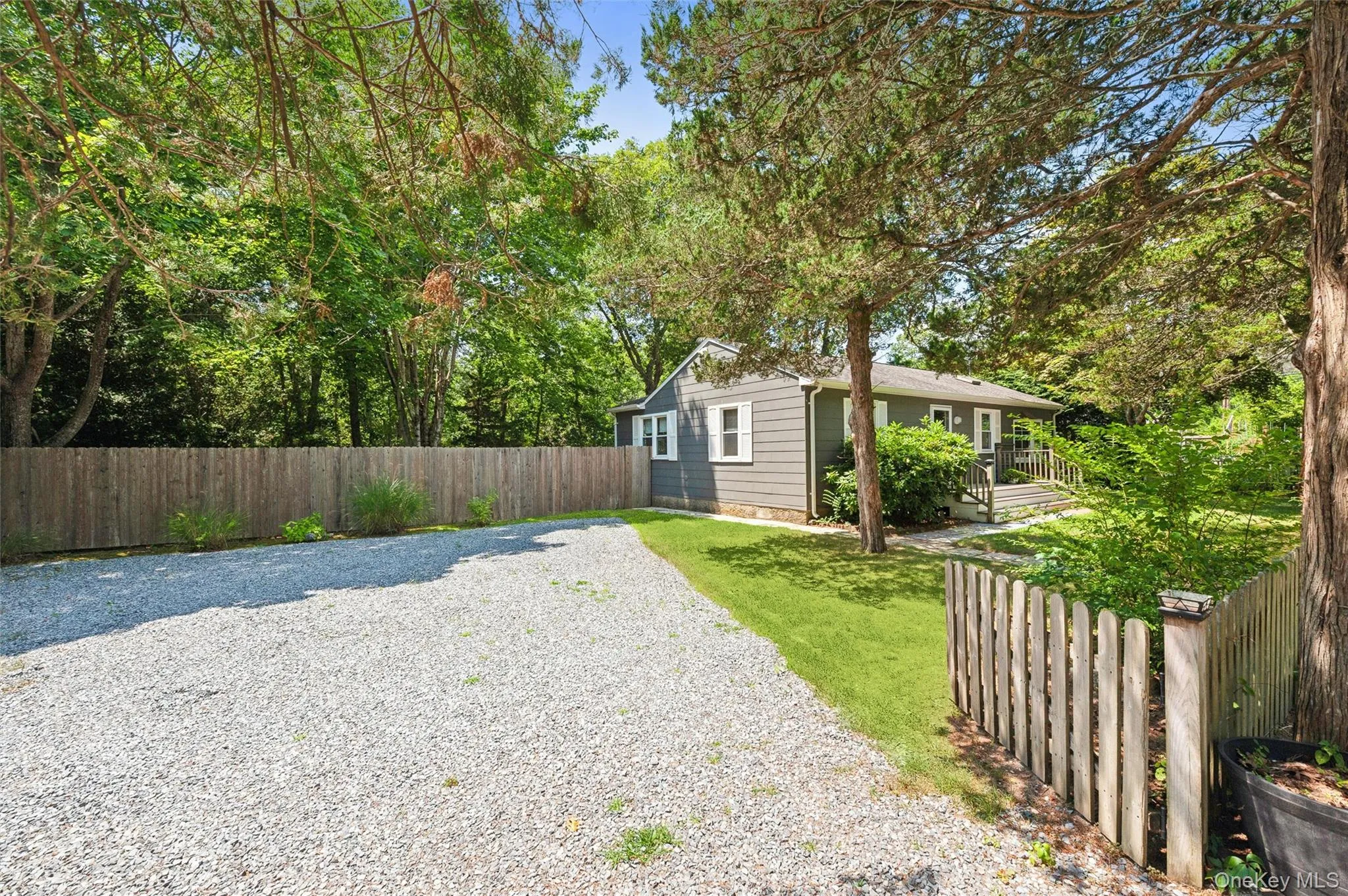 Fenced backyard with a deck and view of scattered trees Fenced backyard with a deck and view of scattered trees