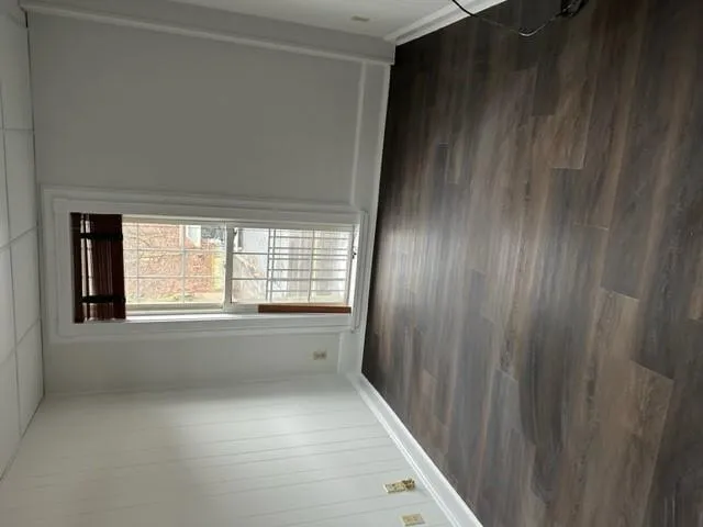 Empty room with a drop ceiling and dark wood-style flooring Empty room with a drop ceiling and dark wood-style flooring
