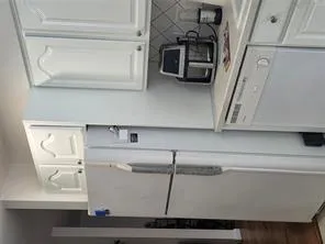 Kitchen with freestanding refrigerator, dishwashing machine, white cabinets, light countertops, and tasteful backsplash Kitchen with freestanding refrigerator, dishwashing machine, white cabinets, light countertops, and tasteful backsplash