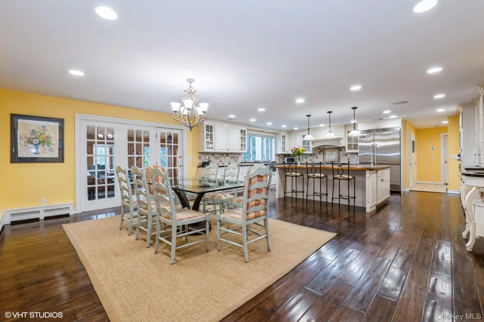 Dining room with dark wood-style flooring, recessed lighting, a chandelier, a baseboard radiator, and french doors Dining room with dark wood-style flooring, recessed lighting, a chandelier, a baseboard radiator, and french doors