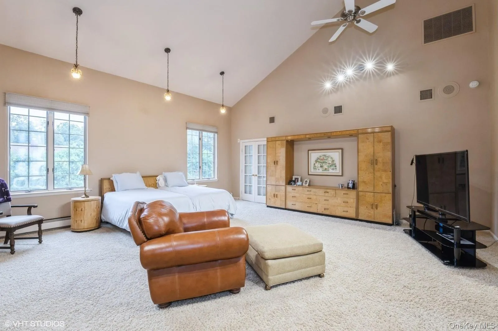 Bedroom featuring high vaulted ceiling, carpet floors, access to exterior, and a ceiling fan Bedroom featuring high vaulted ceiling, carpet floors, access to exterior, and a ceiling fan