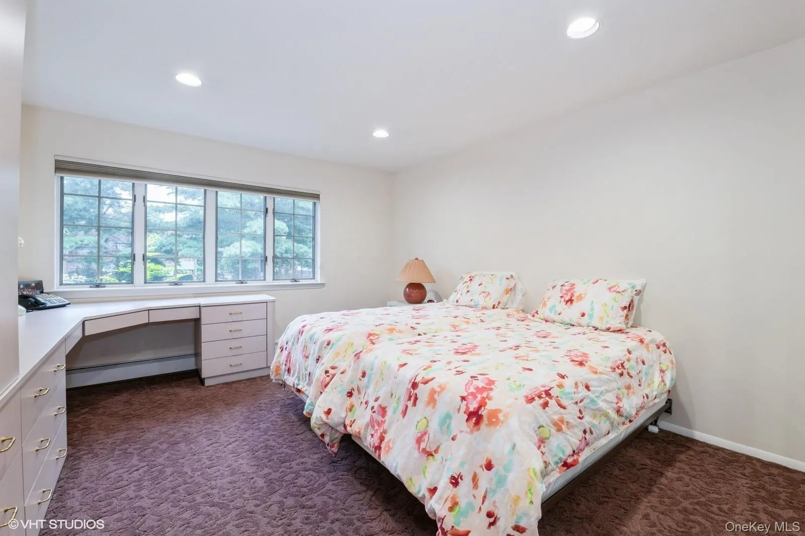 Bedroom with dark carpet, recessed lighting, a baseboard radiator, and an office area Bedroom with dark carpet, recessed lighting, a baseboard radiator, and an office area