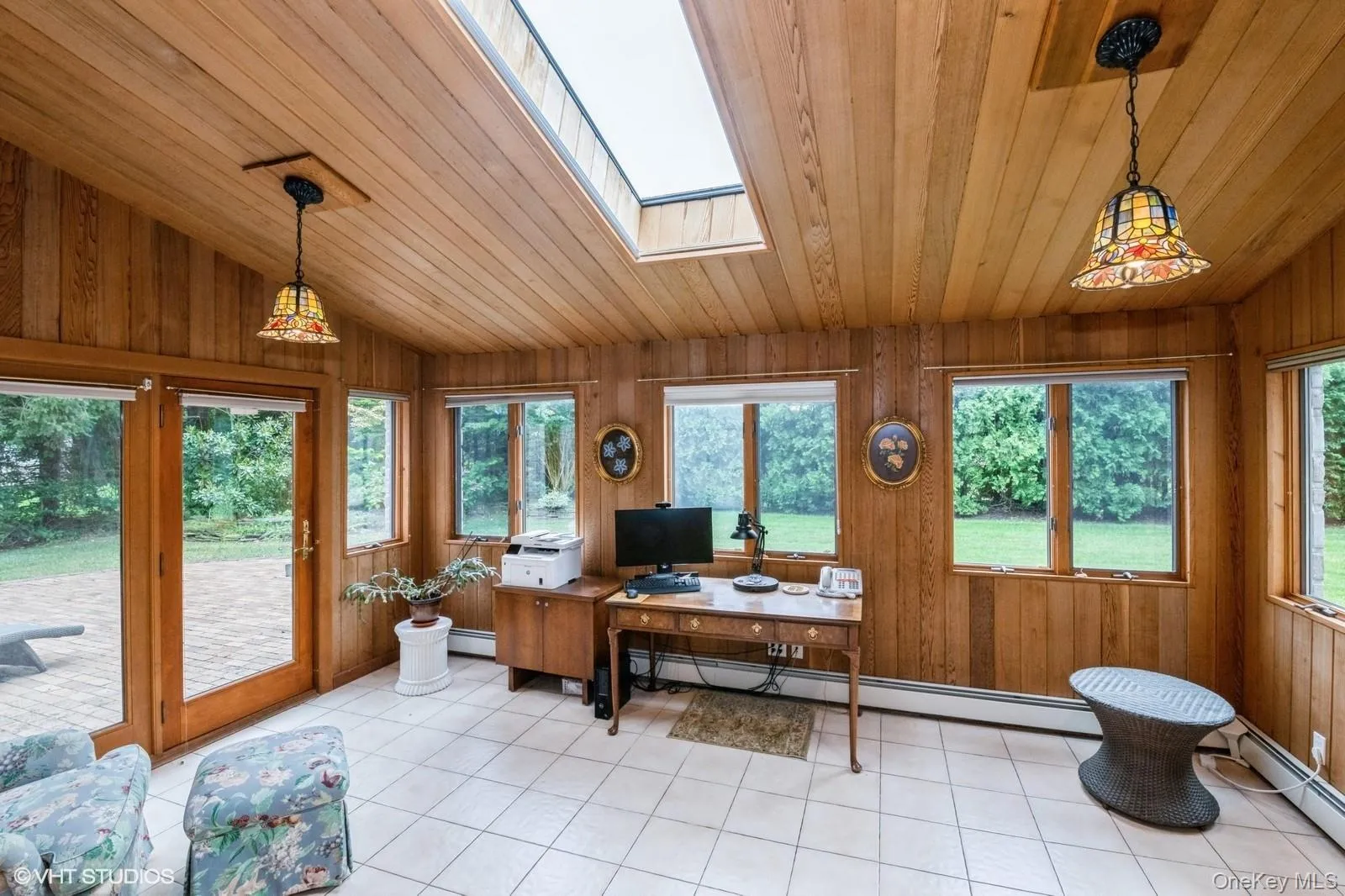 Home office featuring wooden walls, vaulted ceiling, wooden ceiling, light tile patterned floors, and baseboard heating Home office featuring wooden walls, vaulted ceiling, wooden ceiling, light tile patterned floors, and baseboard heating