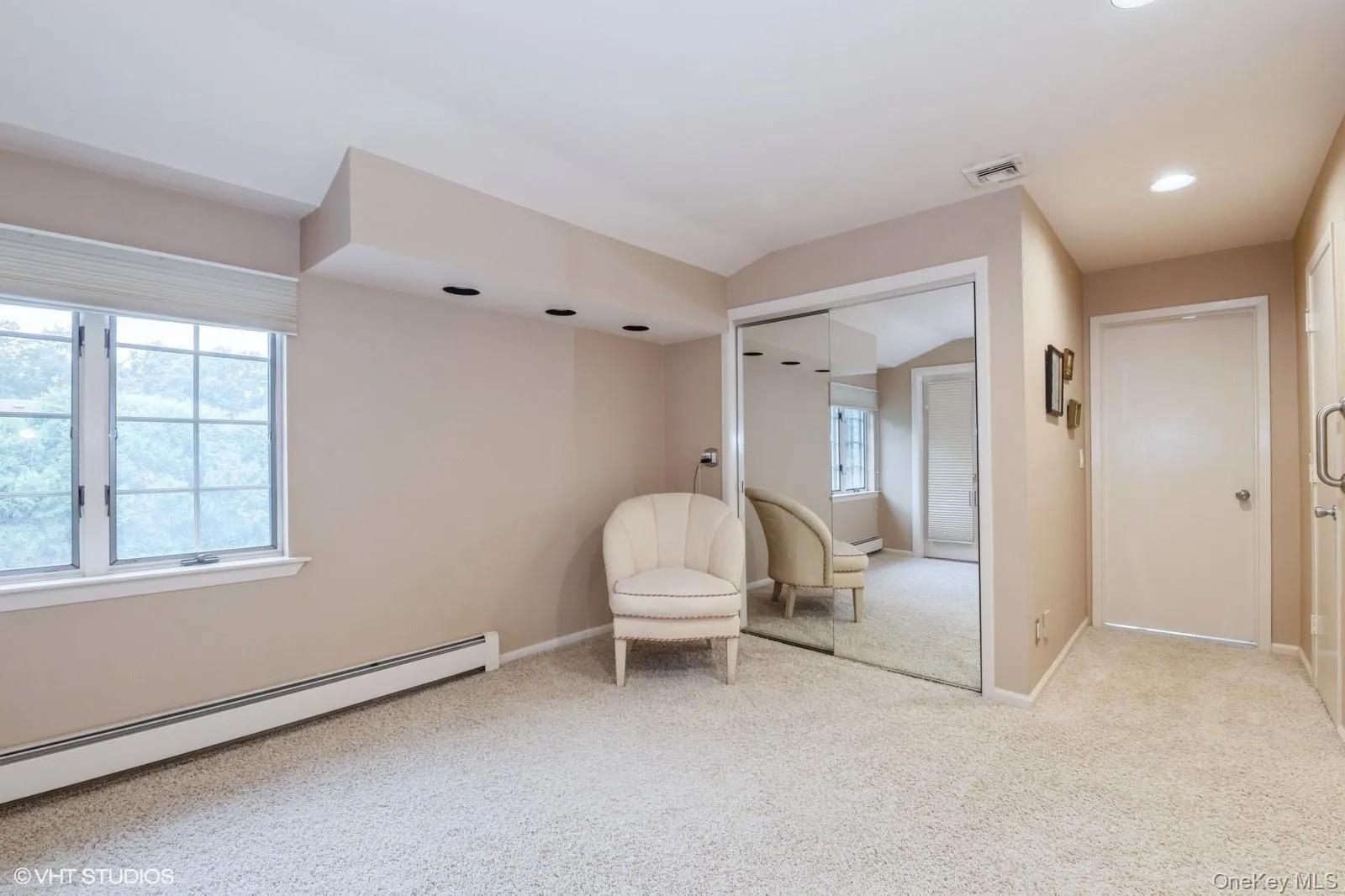 Living area with light colored carpet, baseboard heating, and recessed lighting Living area with light colored carpet, baseboard heating, and recessed lighting
