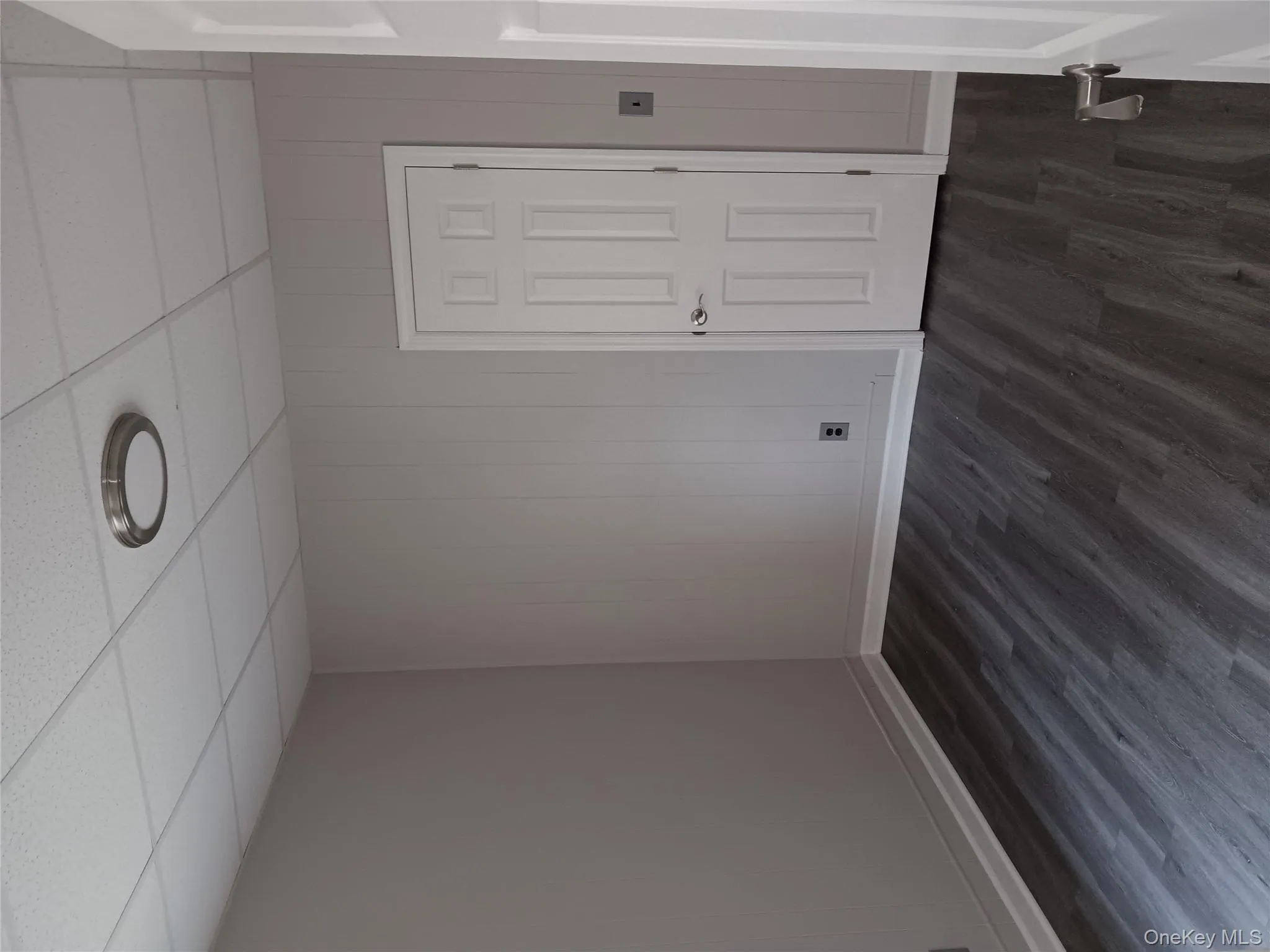 Unfurnished room with a paneled ceiling, dark wood-type flooring, and wood walls Unfurnished room with a paneled ceiling, dark wood-type flooring, and wood walls