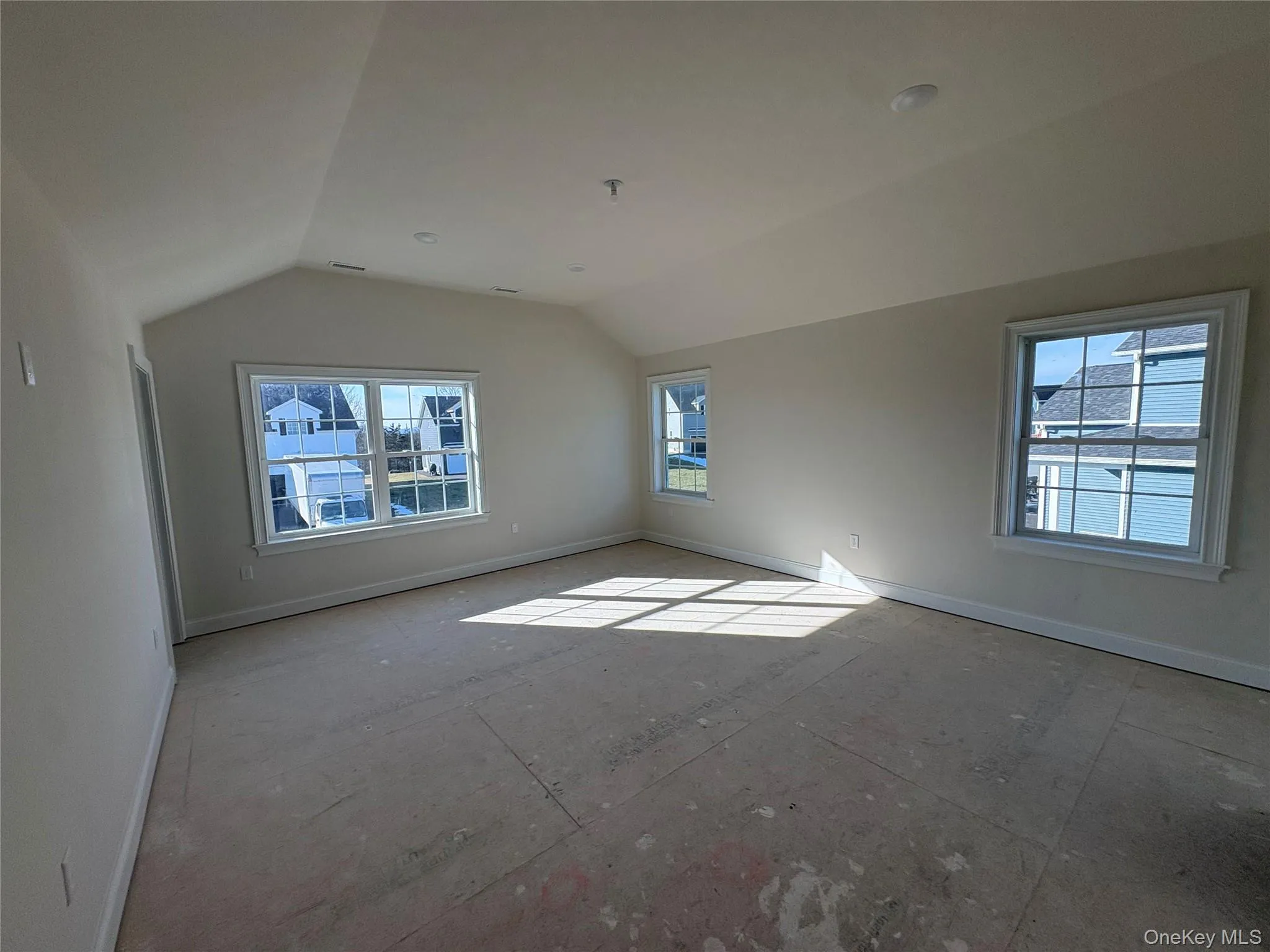 Empty room with healthy amount of natural light and lofted ceiling Empty room with healthy amount of natural light and lofted ceiling