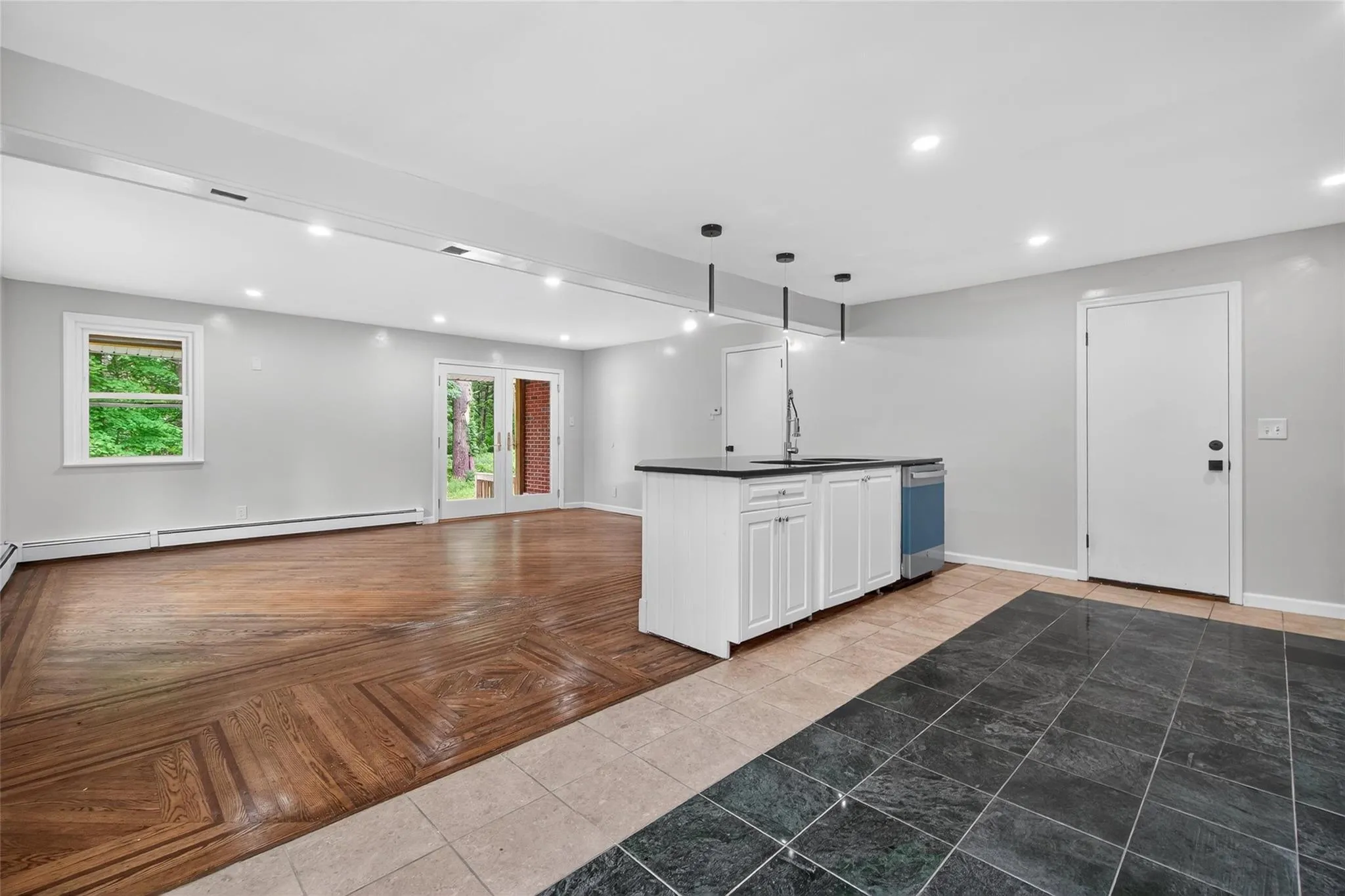 Kitchen featuring dark countertops, baseboard heating, dishwasher, plenty of natural light, and recessed lighting Kitchen featuring dark countertops, baseboard heating, dishwasher, plenty of natural light, and recessed lighting
