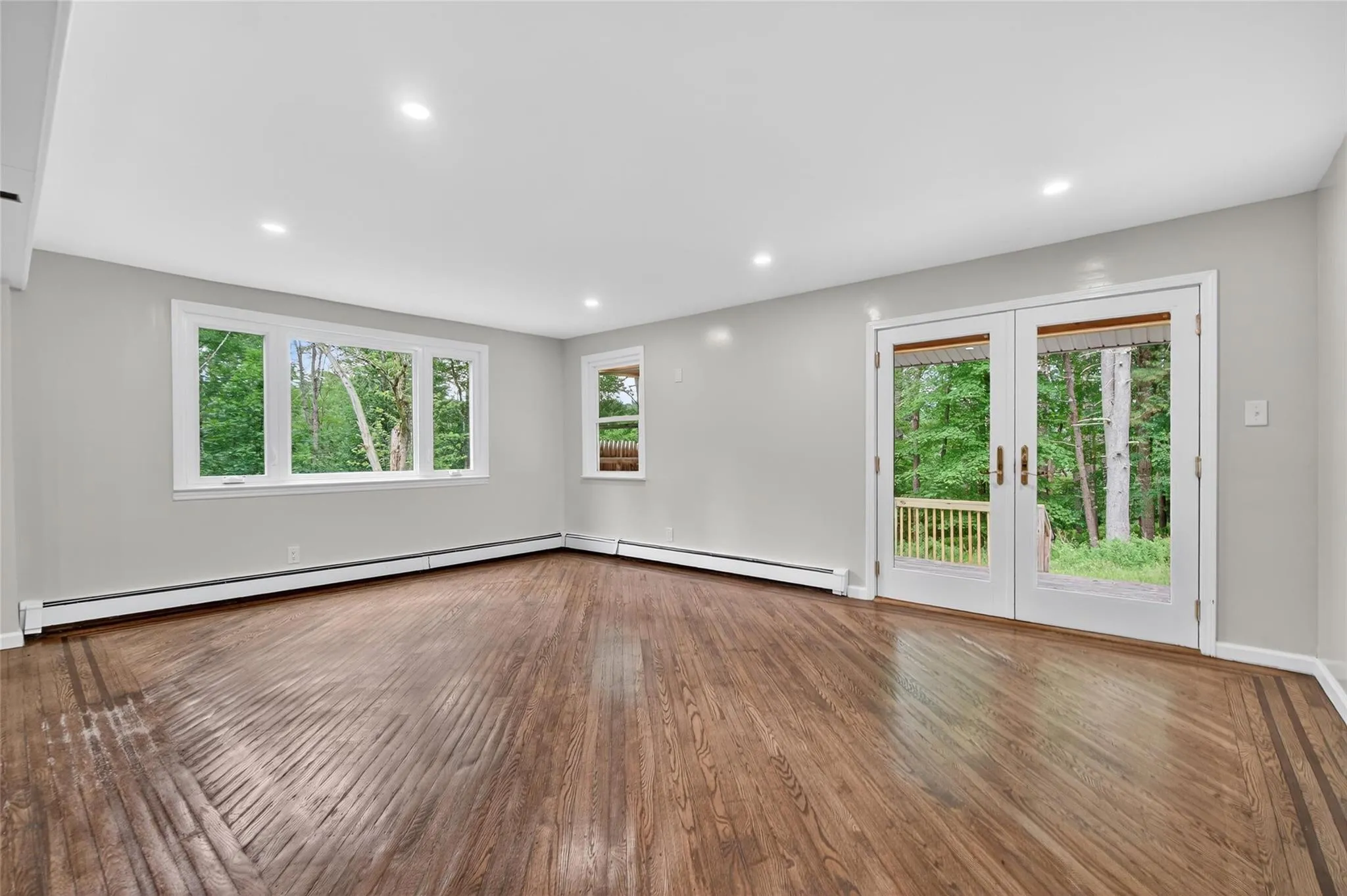 Unfurnished room with french doors, wood finished floors, baseboard heating, and recessed lighting Unfurnished room with french doors, wood finished floors, baseboard heating, and recessed lighting