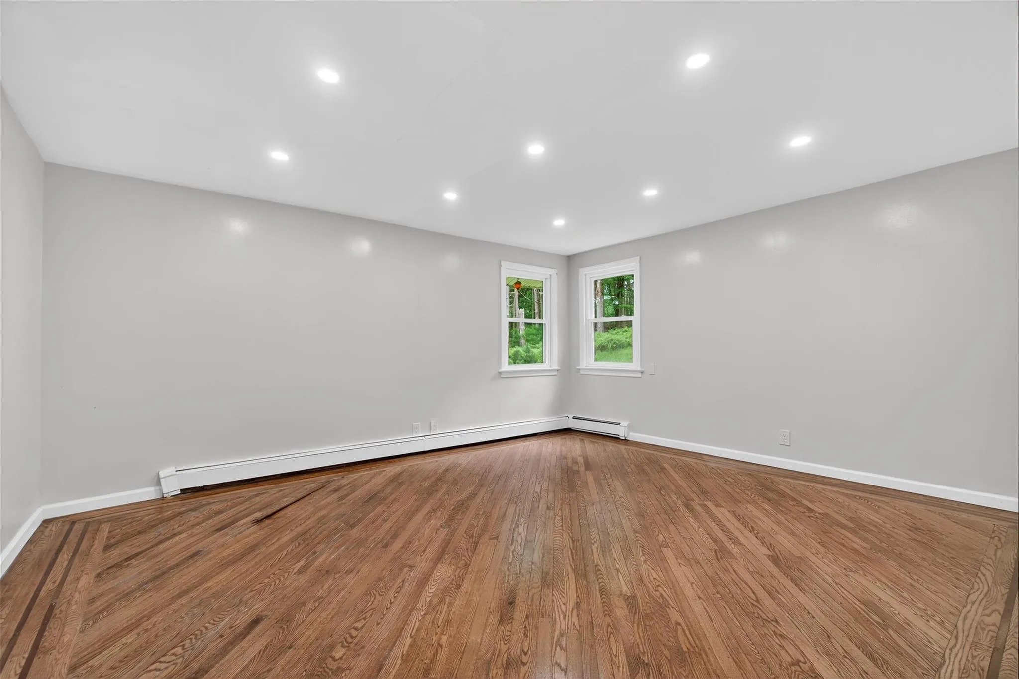 Spare room with a baseboard heating unit, wood finished floors, and recessed lighting Spare room with a baseboard heating unit, wood finished floors, and recessed lighting
