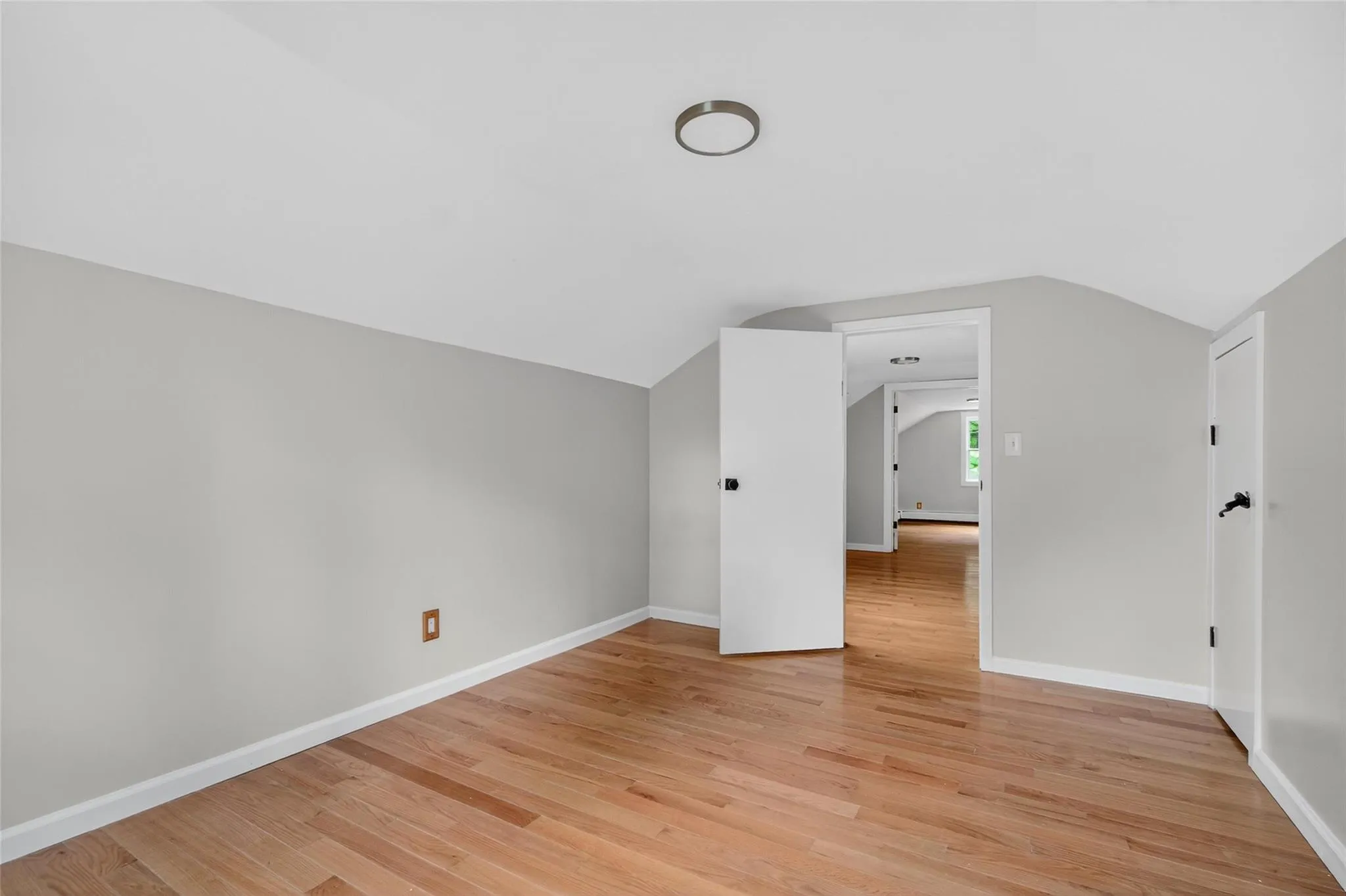 Additional living space with vaulted ceiling and light wood-style flooring Additional living space with vaulted ceiling and light wood-style flooring