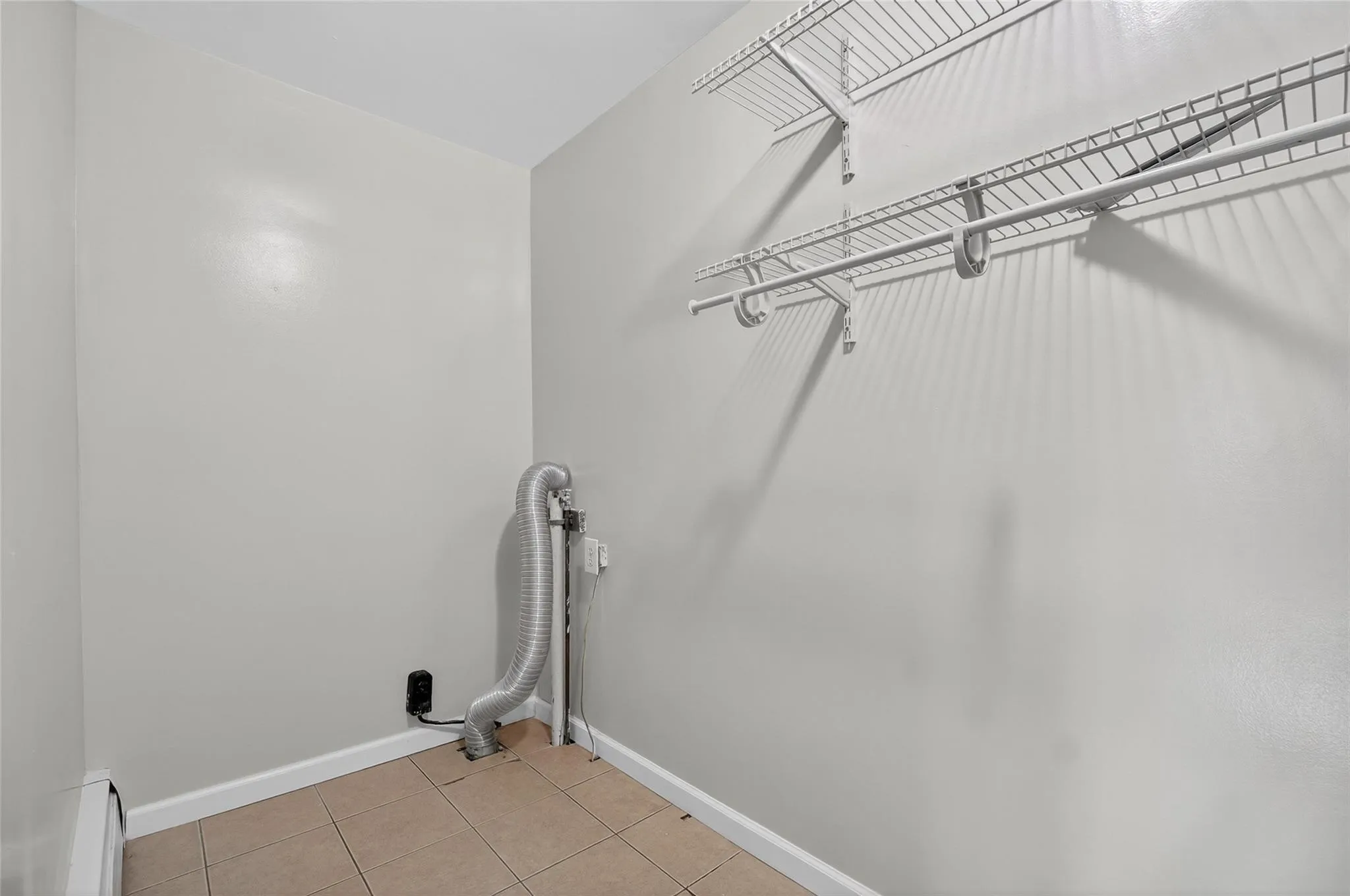 Washroom with a baseboard radiator and light tile patterned floors Washroom with a baseboard radiator and light tile patterned floors