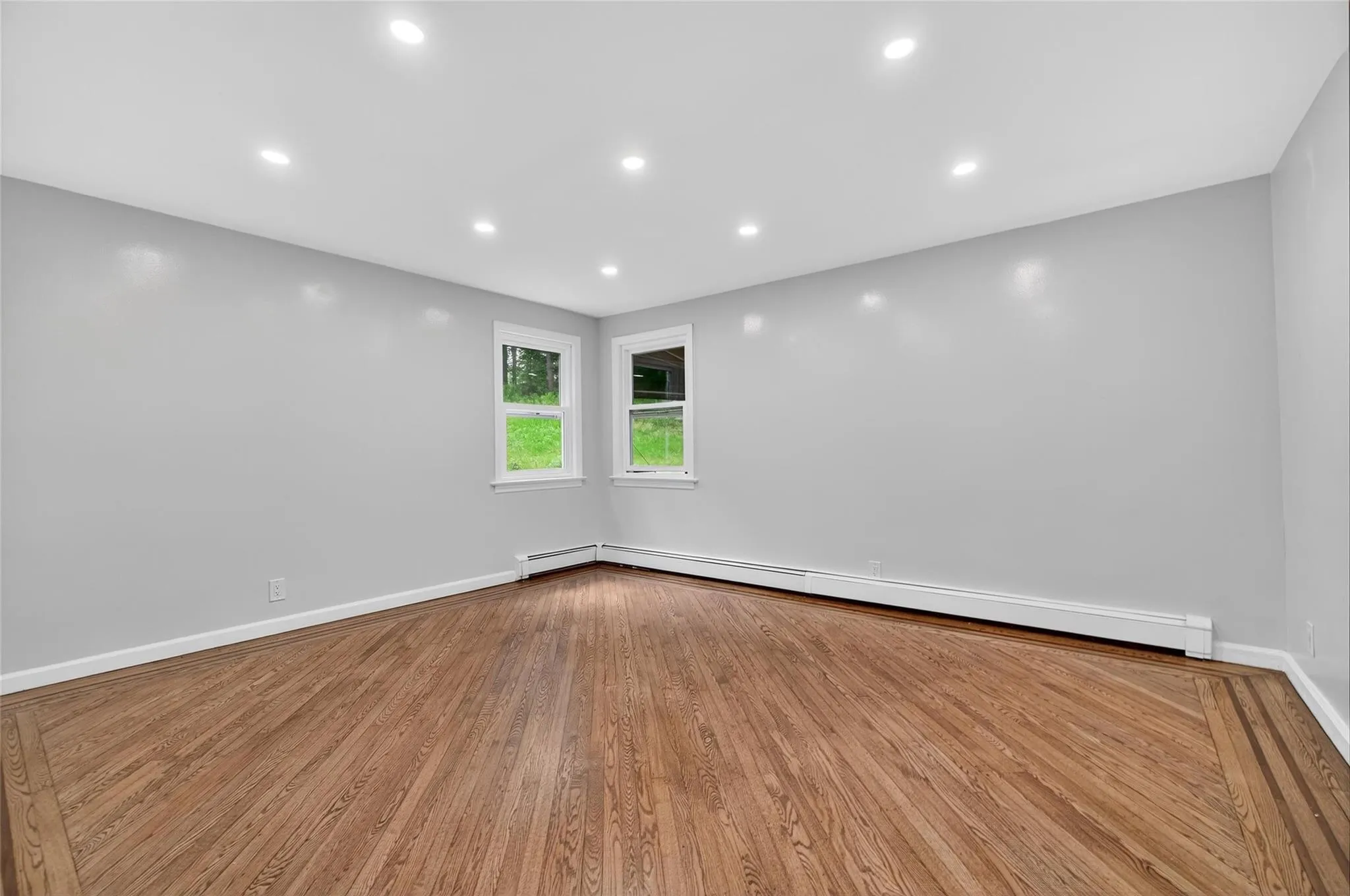 Spare room with a baseboard heating unit, wood finished floors, and recessed lighting Spare room with a baseboard heating unit, wood finished floors, and recessed lighting