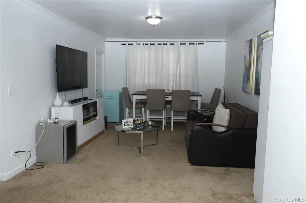 Carpeted living room featuring crown molding Carpeted living room featuring crown molding
