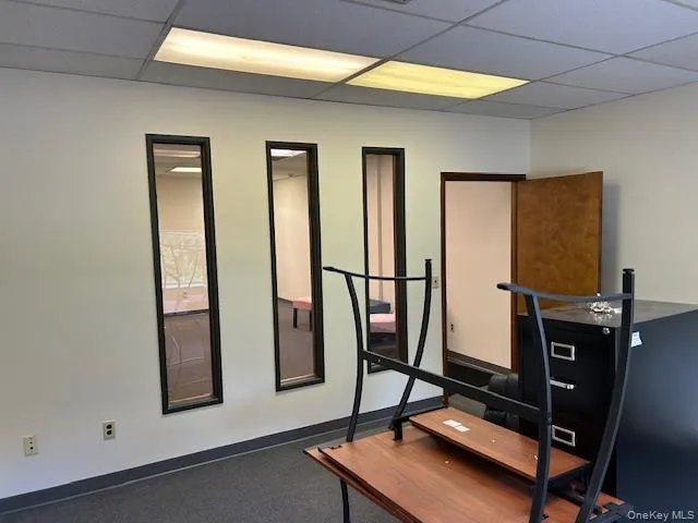 Exercise area featuring a drop ceiling and baseboards Exercise area featuring a drop ceiling and baseboards
