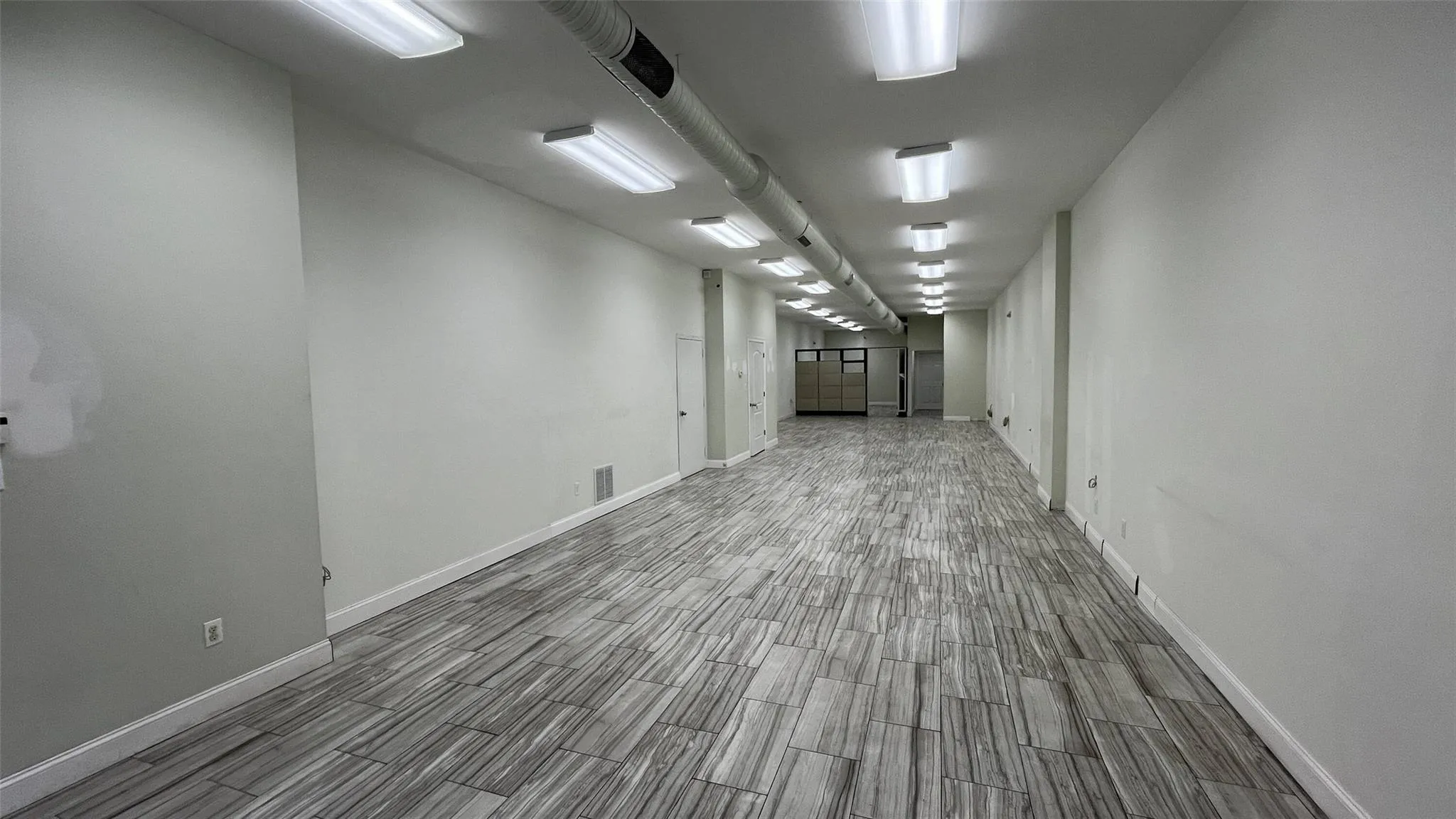 Spare room featuring baseboards and wood tiled floors Spare room featuring baseboards and wood tiled floors