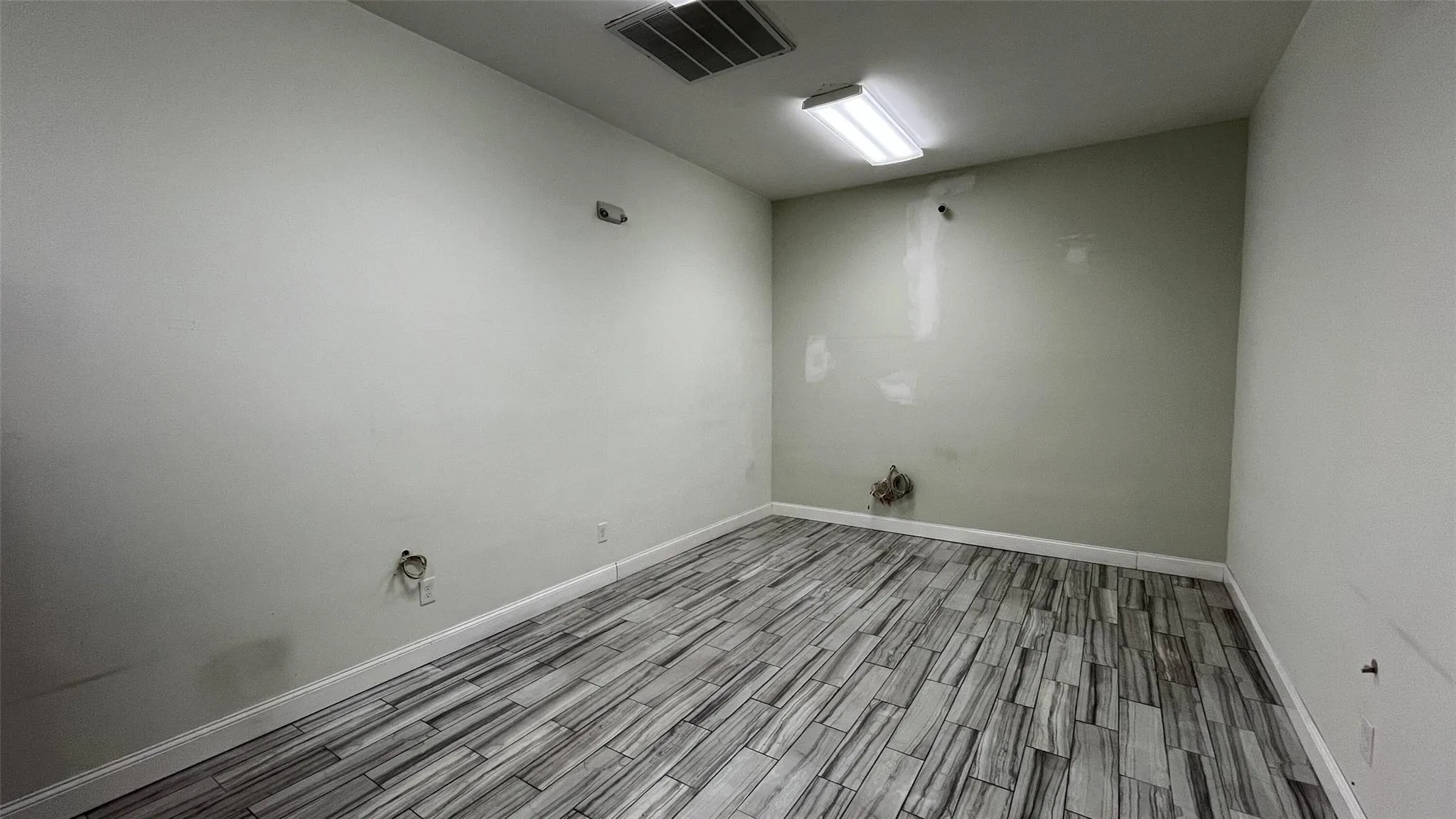 Empty room with wood finished floors and baseboards Empty room with wood finished floors and baseboards