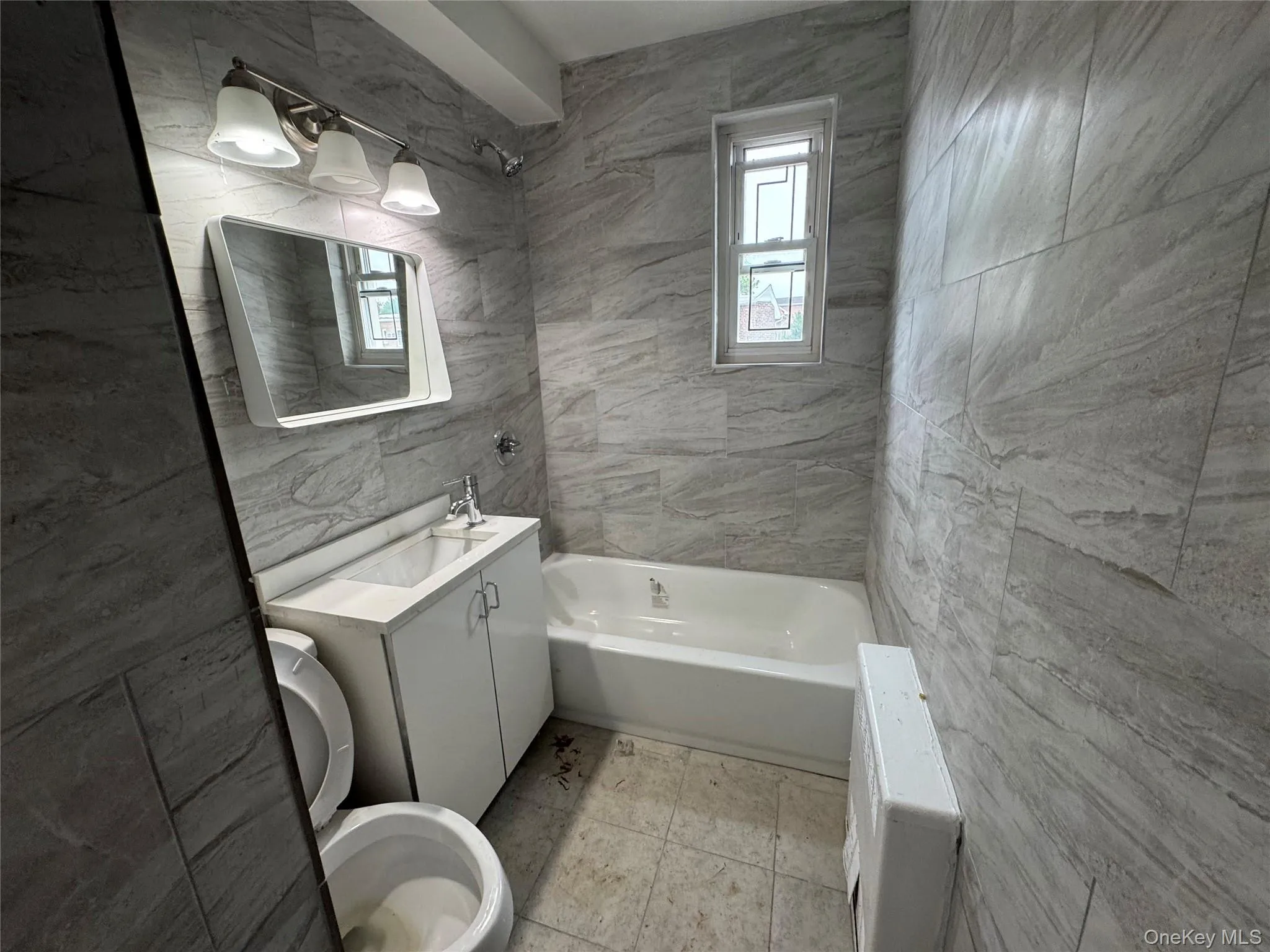 Full bath featuring tile walls, plenty of natural light, and vanity Full bath featuring tile walls, plenty of natural light, and vanity