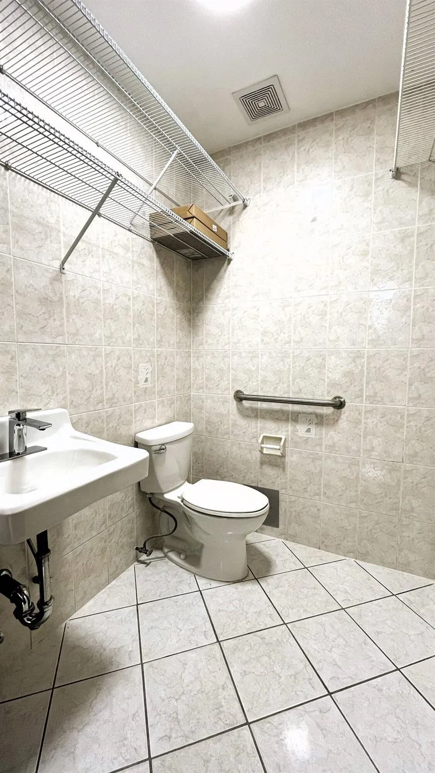 Bathroom featuring tile walls and tile patterned floors Bathroom featuring tile walls and tile patterned floors