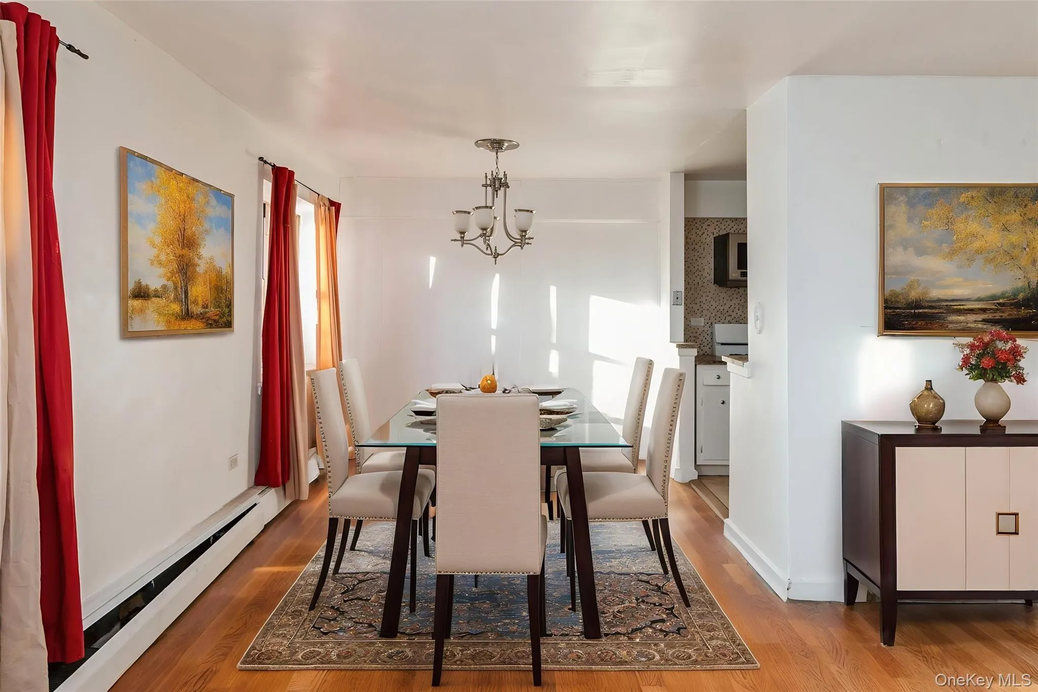 Dining space with a baseboard radiator, a chandelier, and wood finished floors Dining space with a baseboard radiator, a chandelier, and wood finished floors