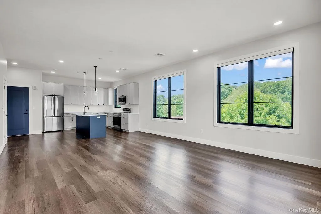 Unfurnished living room with recessed lighting and dark wood-type flooring Unfurnished living room with recessed lighting and dark wood-type flooring