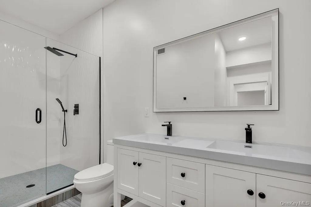 Full bathroom with a stall shower, double vanity, and recessed lighting Full bathroom with a stall shower, double vanity, and recessed lighting