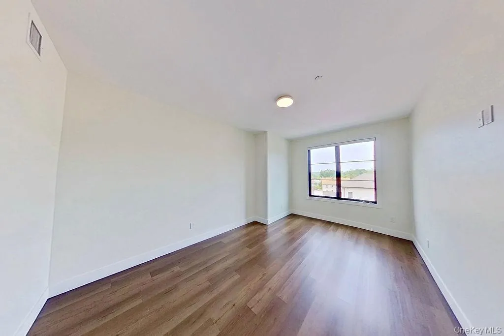 Empty room featuring wood finished floors and baseboards Empty room featuring wood finished floors and baseboards