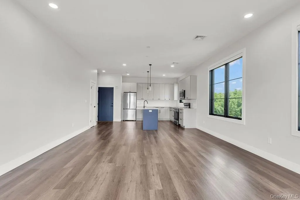 Unfurnished living room featuring wood finished floors and recessed lighting Unfurnished living room featuring wood finished floors and recessed lighting