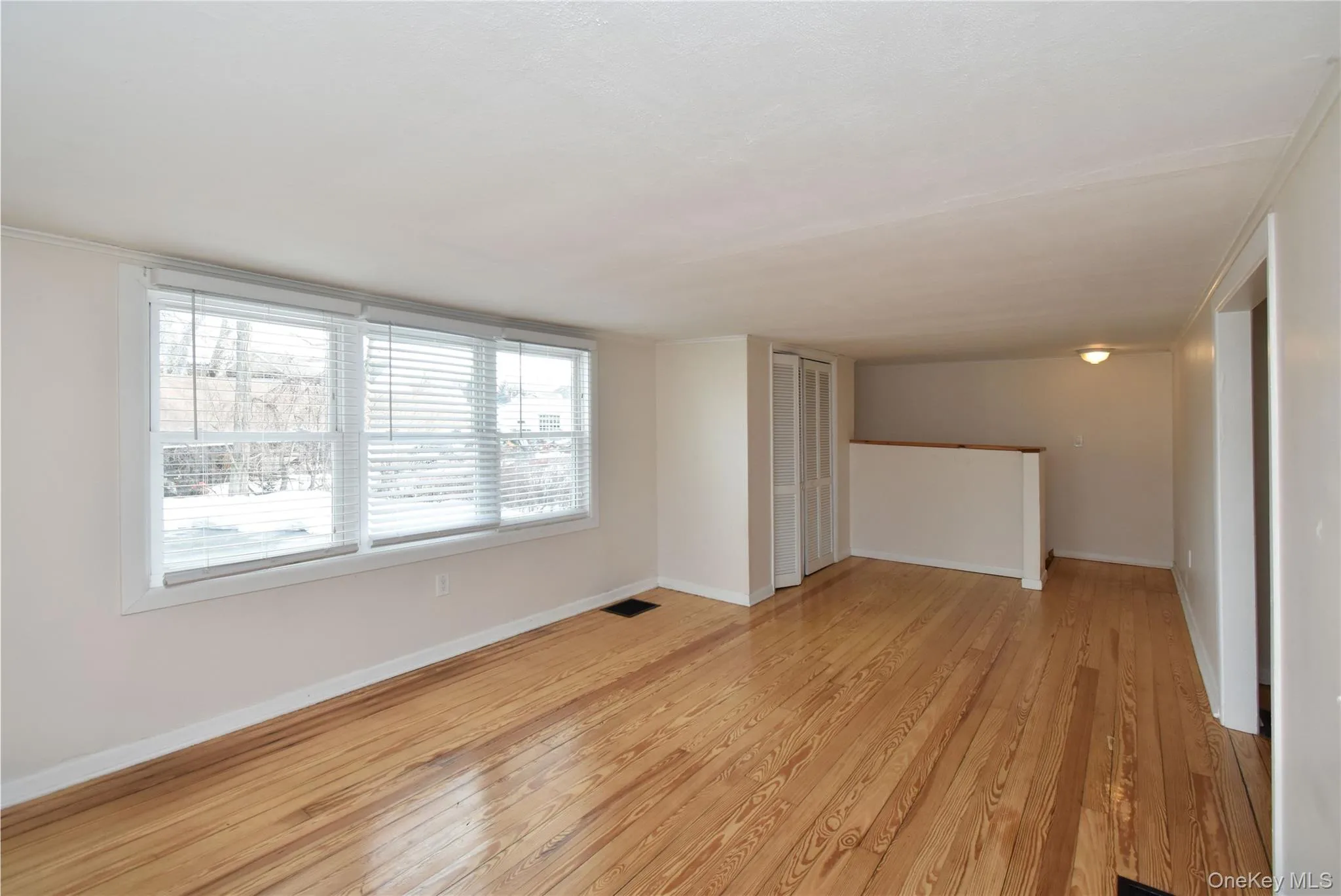 Empty room with light wood finished floors and baseboards Empty room with light wood finished floors and baseboards