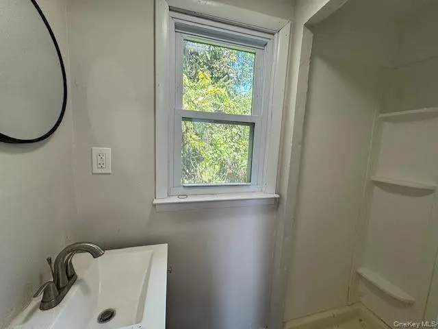 Bathroom featuring a sink and a shower Bathroom featuring a sink and a shower