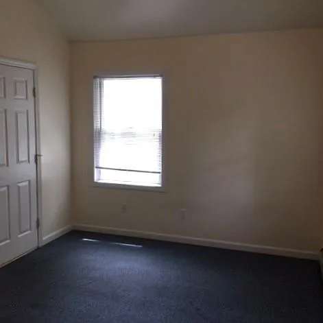 Carpeted empty room with vaulted ceiling Carpeted empty room with vaulted ceiling
