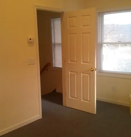 Hallway with dark colored carpet and a wealth of natural light Hallway with dark colored carpet and a wealth of natural light
