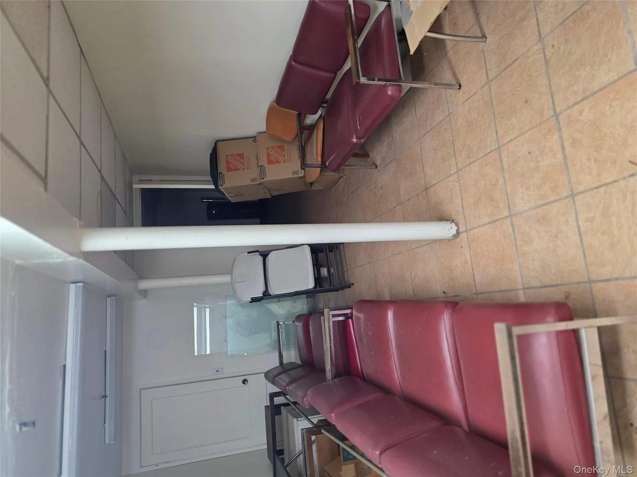 Living room featuring a drop ceiling and light tile patterned floors Living room featuring a drop ceiling and light tile patterned floors