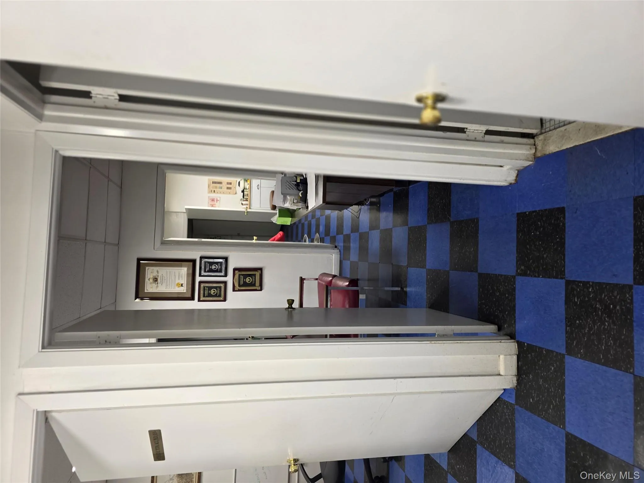 Hall featuring a paneled ceiling and dark flooring Hall featuring a paneled ceiling and dark flooring