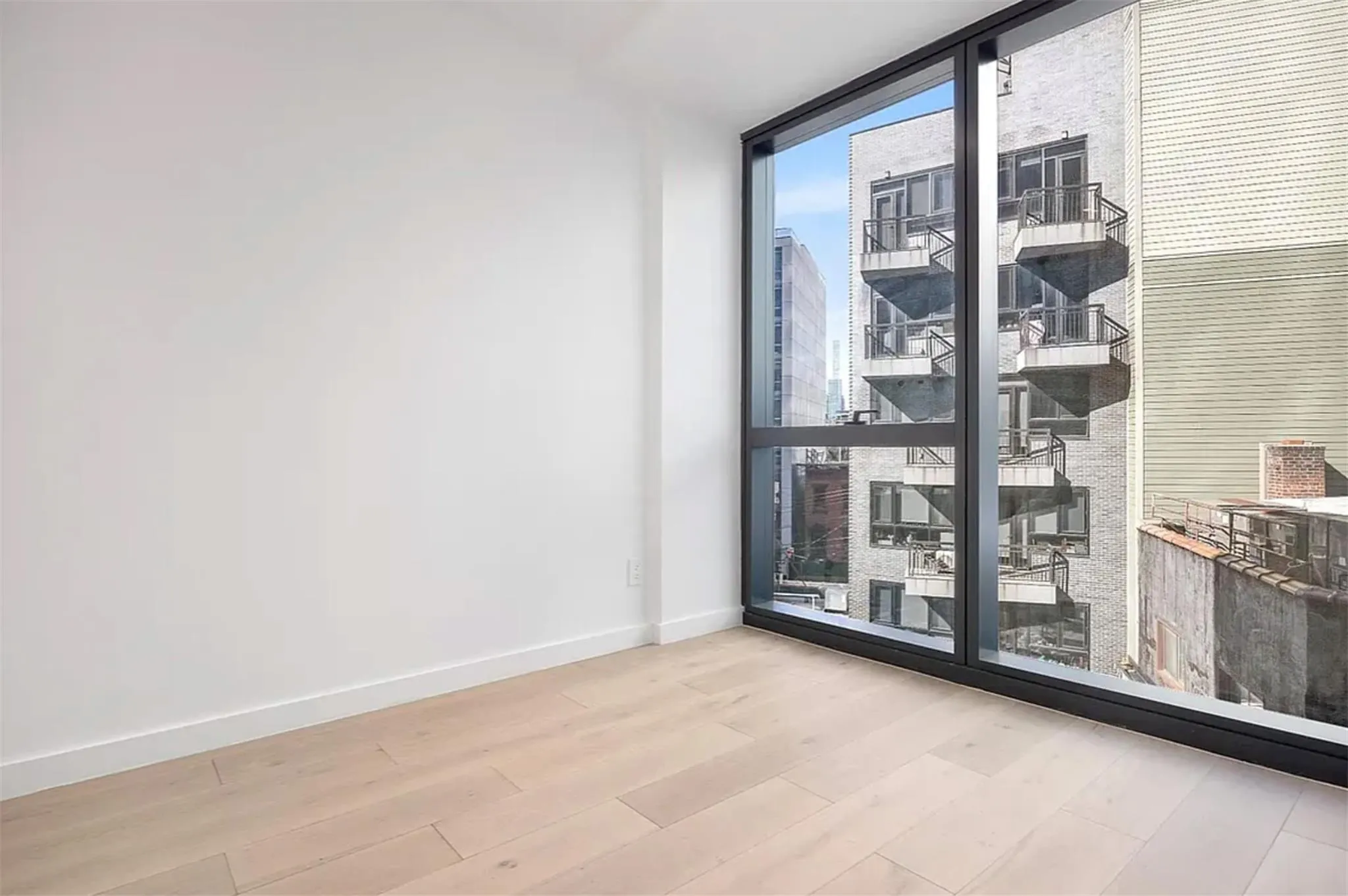Spare room with floor to ceiling windows and wood finished floors Spare room with floor to ceiling windows and wood finished floors