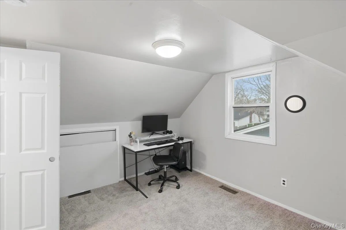 Office featuring vaulted ceiling and light colored carpet Office featuring vaulted ceiling and light colored carpet