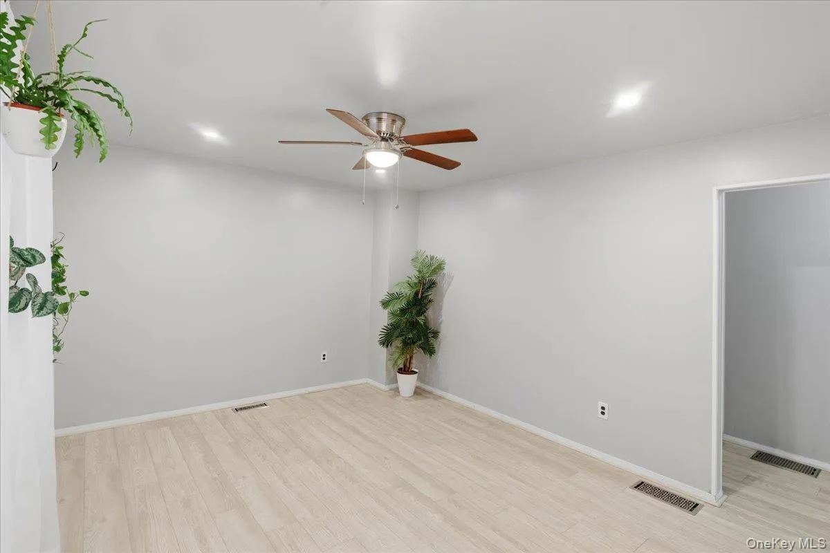 Spare room featuring ceiling fan and light wood-style floors Spare room featuring ceiling fan and light wood-style floors