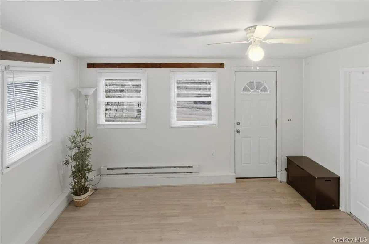 Entryway with light wood finished floors, a baseboard radiator, and a ceiling fan Entryway with light wood finished floors, a baseboard radiator, and a ceiling fan