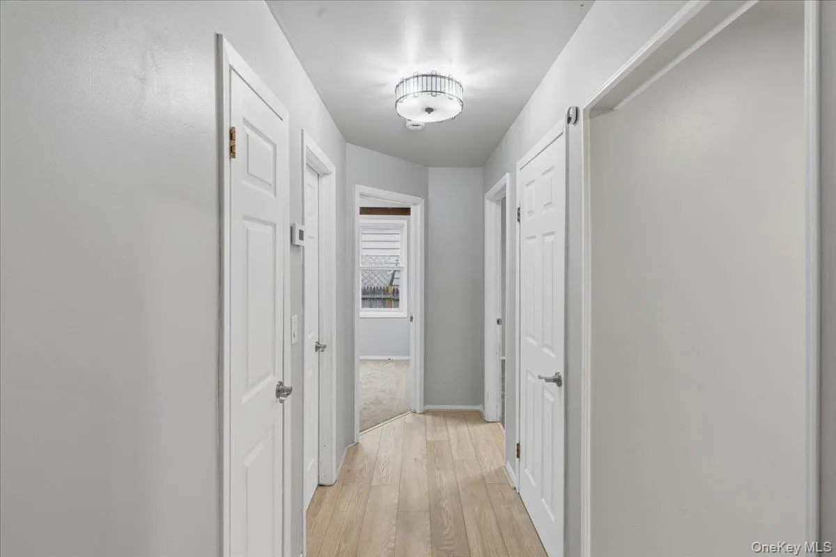 Hall with light wood-type flooring and baseboards Hall with light wood-type flooring and baseboards
