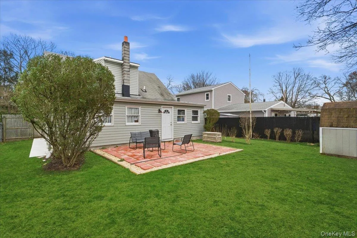Rear view of house featuring a patio, a fenced backyard, and a chimney Rear view of house featuring a patio, a fenced backyard, and a chimney