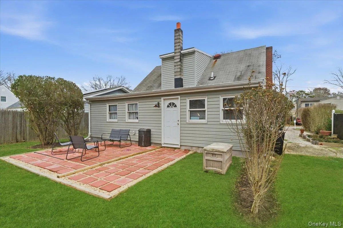 Rear view of house featuring a patio, a chimney, and roof with shingles Rear view of house featuring a patio, a chimney, and roof with shingles