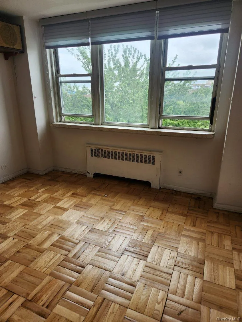 Unfurnished room featuring radiator heating unit and plenty of natural light Unfurnished room featuring radiator heating unit and plenty of natural light