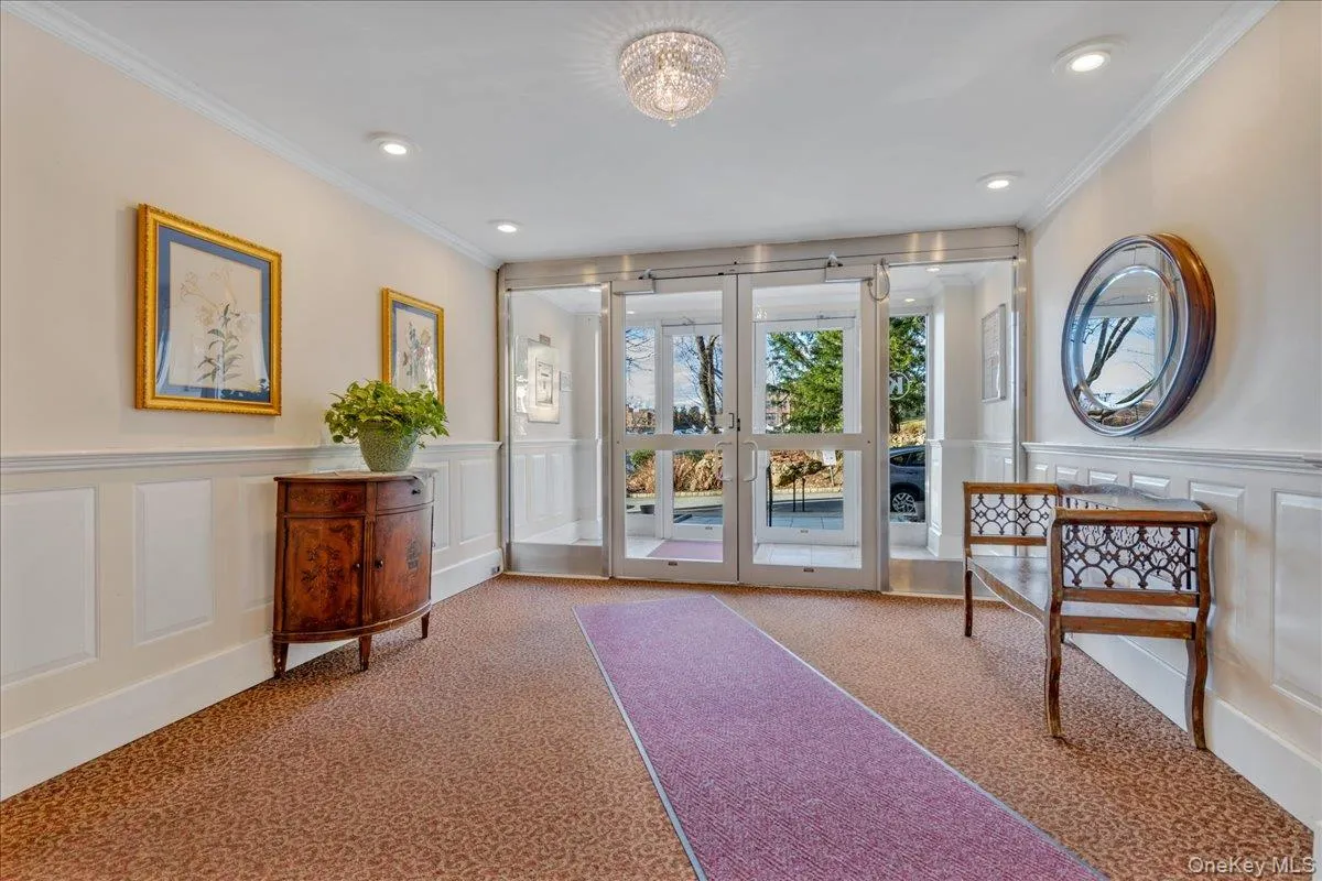 Doorway with a decorative wall, carpet flooring, crown molding, wainscoting, and recessed lighting Doorway with a decorative wall, carpet flooring, crown molding, wainscoting, and recessed lighting